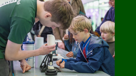 Photograph Dr Cameron Woodgate and a child using the -Crusher- demonstrator. Image credit © Brendan Foster Photography